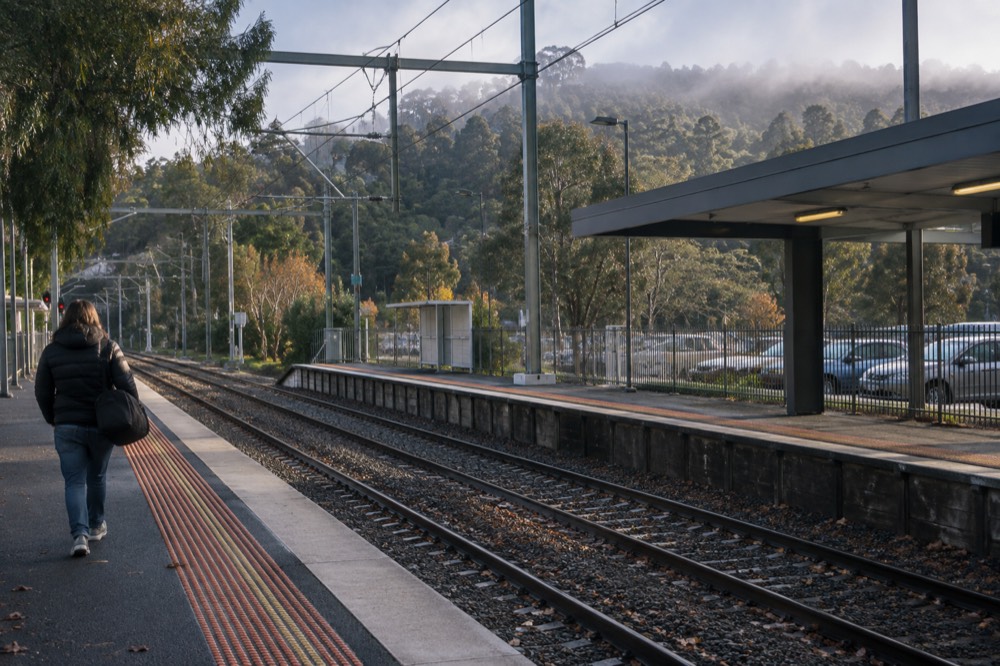 A regional train platform at a country station with hills behind it