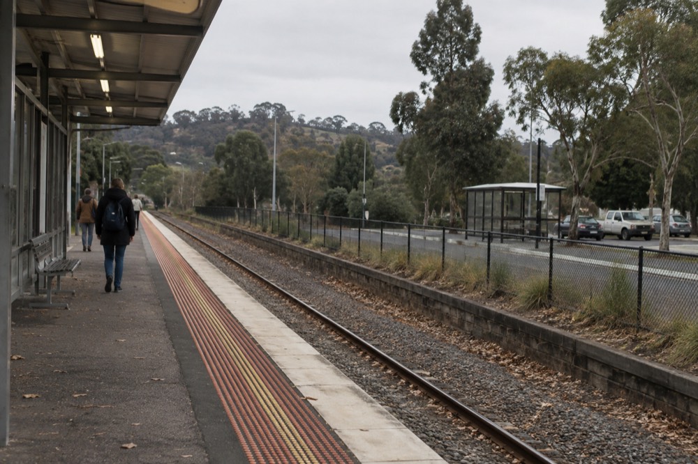 Country railway platform with gum trees and a waiting bus shelter