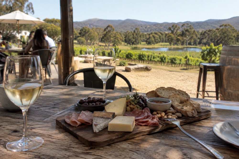 Grazing board of cheese, cured meats and bread on a wooden table at a winery
